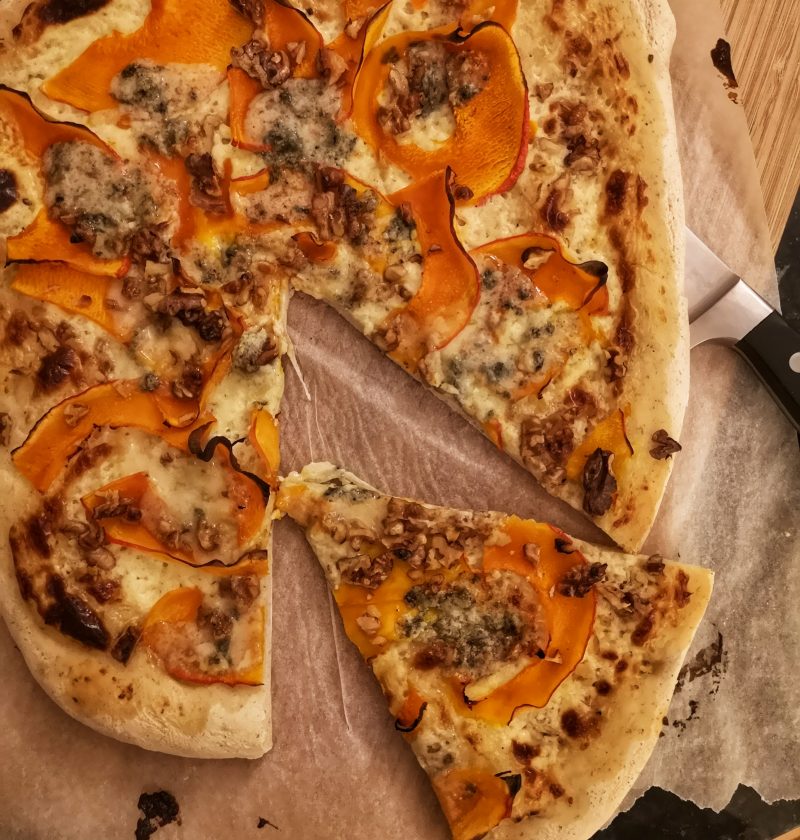 Pizza blanche au potimarron avec planche en bois et couteau